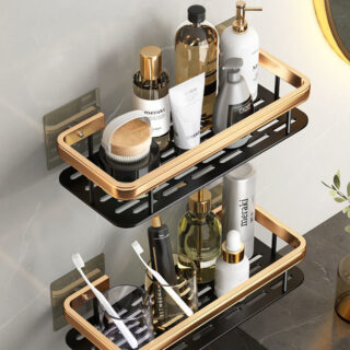Deux étagères murales noir et or rectangulaire l'une au dessus de l'autre portant de nombreux produits de soin, du savon en bouteille et des brosses a dents