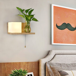 Une étagère en bois avec cube lumineux et plante posée sur la tablette, fixée sur le mur d'une chambre à coucher.