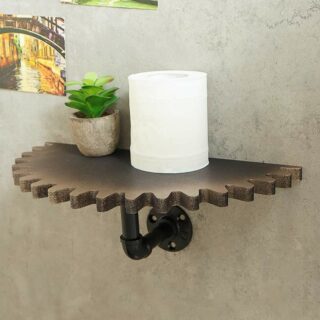 Etagère murale noire style industriel en forme de roue cranté sur laquelle repose une plante en pot et une bougie blanche