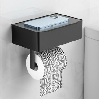 Près de toilettes, on voit une petite étagère noire, épaisse à laquelle est suspendue un rouleau de papier toilette à motif graphique noir et blanc.