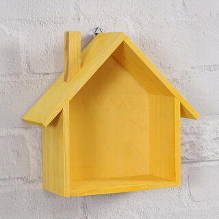 Sur un mur en pierre blanc, on voit une étagère murale en forme de maisonnette. Elle est en bois et peinte en jaune.
