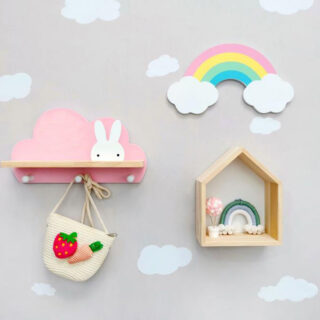 Photo d'une étagère murale en bois, en forme de nuage rose avec un étagère murale en forme de maison et une décoration murale arc-en-ciel, sur un mur avec des petits nuages.