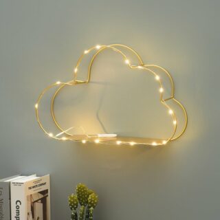 Une étagère murale en métal avec un éclairage LED sur un mur gris au dessus d'un meuble décoré de livres et d'un cactus.