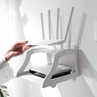 une main pose un routeur internet sur une étagère accessoires télévision blanche, fixée sur un mur blanc