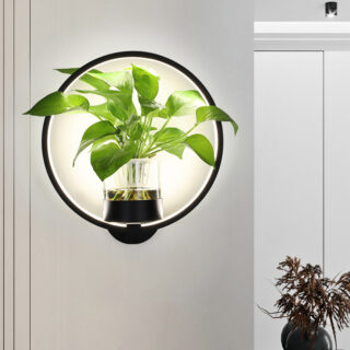 Applique murale LED ronde avec une plante dedans, fixée sur un mur blanc.