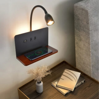 Étagère murale LED avec chargeur sans fil et prise USB avec un téléphone posé dessus et une table de chevet en dessous avec un pot de fleur et des livres