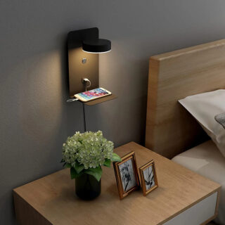 Étagère murale LED design avec port USB installée sur un mur à côté d'un lit et au-dessus d'une table de nuit avec des cadres et un pot de fleur