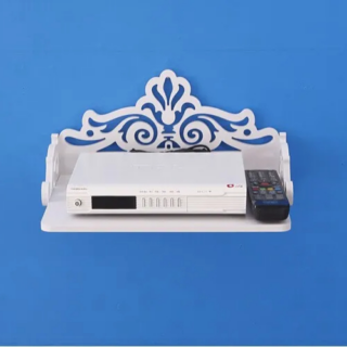 Étagère murale TV en bois pour décodeur effet sculpté installée sur un mur bleu avec un décodeur et une télécommande posée dessus