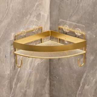 Étagère murale douche de couleur dorée ici sur un mur d'angle en carrelage.
