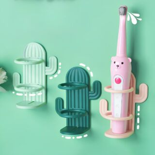 Trois étagères murales en plastique en forme de cactus vert clair, vert et rose. Deux anneaux et un supports plat permettent de maintenir les accessoires. Il y a une brosse à dent électrique rose sur l'étagère rose. Fixées sur un mur vert clair.