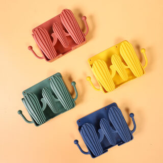 4 étagères murales pour téléphone en forme de cactus sur fond orange. 4 couleurs différentes : orange, vert, jaune et bleu. De chaque côté de l'étagère, un crochet pour suspendre un accessoire.