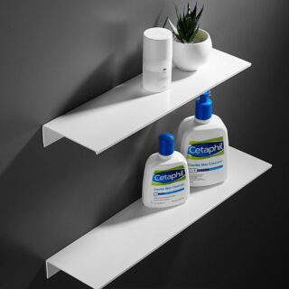 Deux étagères en aluminium blanc, l'une au-dessus de l'autre. Elles sont fixées sur un mur gris foncé. Sur celle du haut, un flacon et une petite plante artificielle, sur celle du bas, deux flacons de cosmétiques.
