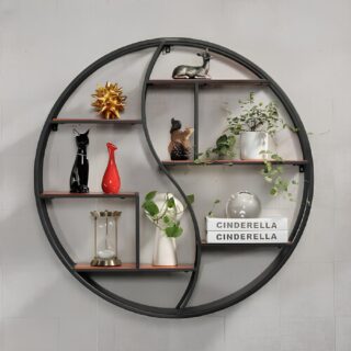étagère ronde en métal noire avec plusieurs étages de rangement. Une ligne ondulée sépare la gauche de la droite. Des objets de décoration se trouvent sur chaque niveau. Sur un mur gris clair.