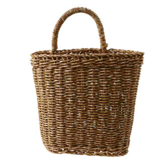 Panier en osier suspendu avec une anse. Sur fond blanc.